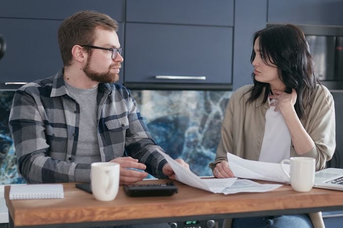 Couple discussing their finances, sat at a table when looking at ways to manage money better.