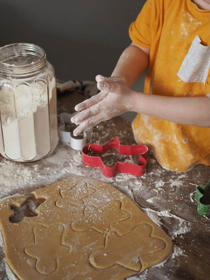 Child baking gingerbread cookies as a fun extracurricular activity.