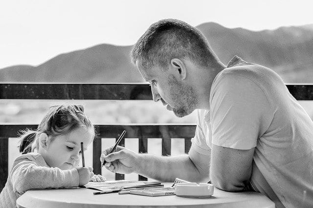Black and white photo of Father and daughter playing a table game