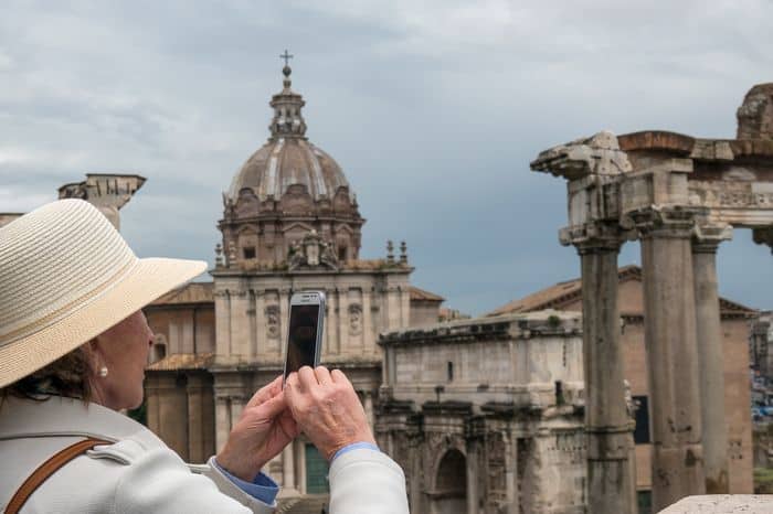 Old lady taken a picture of a monument on a longer vacation.