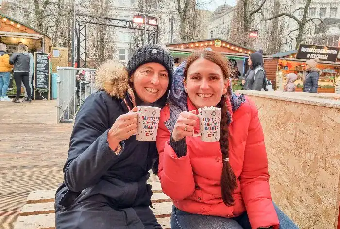 Friends enjoying hot chocolate at the Manchester Christmas Markets