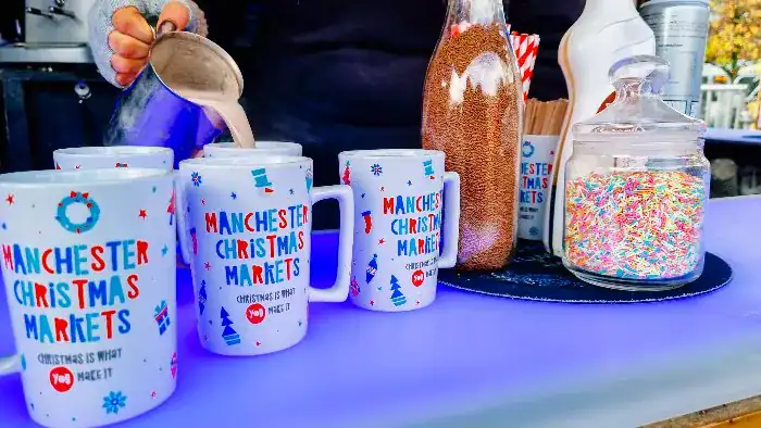 Hot chocolate being poured into Manchester Christmas Market mugs.