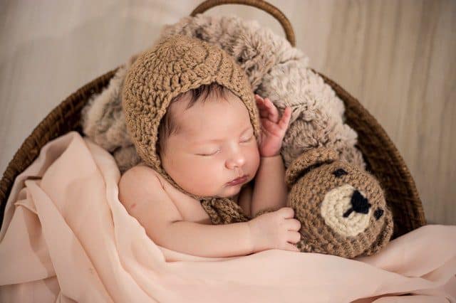 Newborn baby cuddled up and sleeping when bringing a newborn baby home