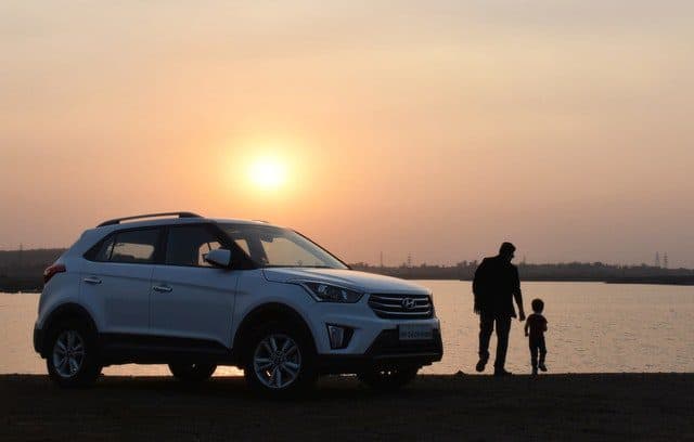 Man and child stood next to a family car