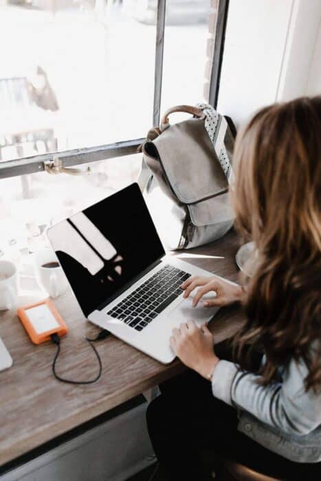 woman sat at desk working on her blog on a laptop to increase domain authority