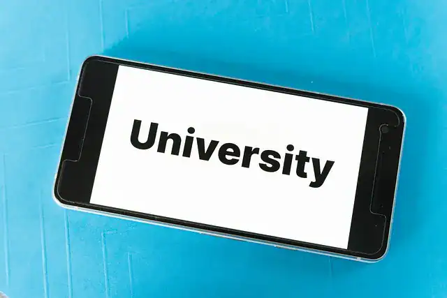 A phone with screen saying University on a blue flat sheet.