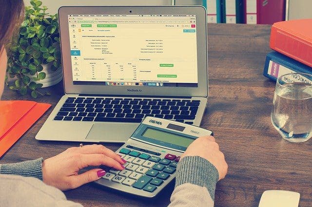 A student working out financials on a laptop which is something they should know before starting college