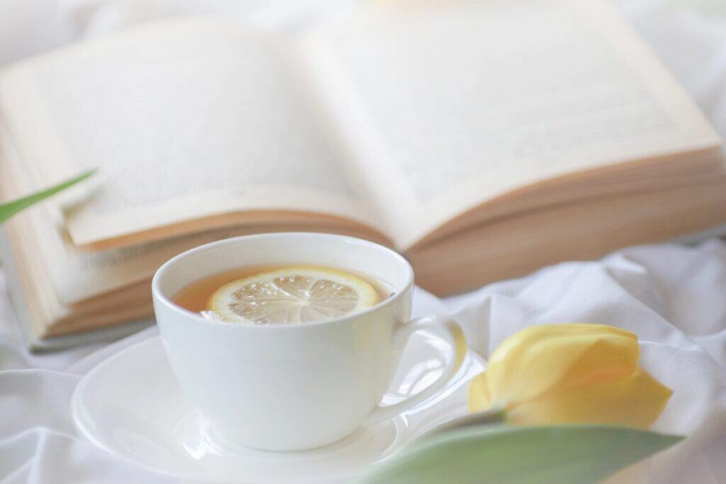 Cup of tea with lemon and book showing simple luxury at home.