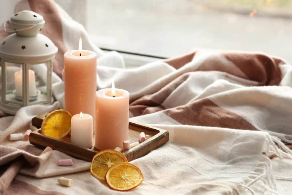 Candles and cosy blanket creating an affordable self-care moment at home.