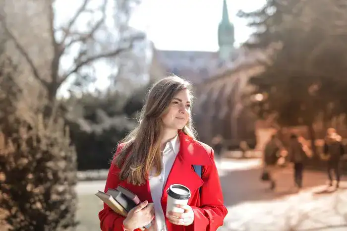 Student walking around campus carrying things bought for university.