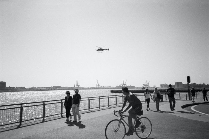cyclist riding amongst people walking on at the seaside