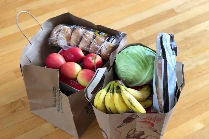 two paper bags of vegetables and fruit from the grocery store