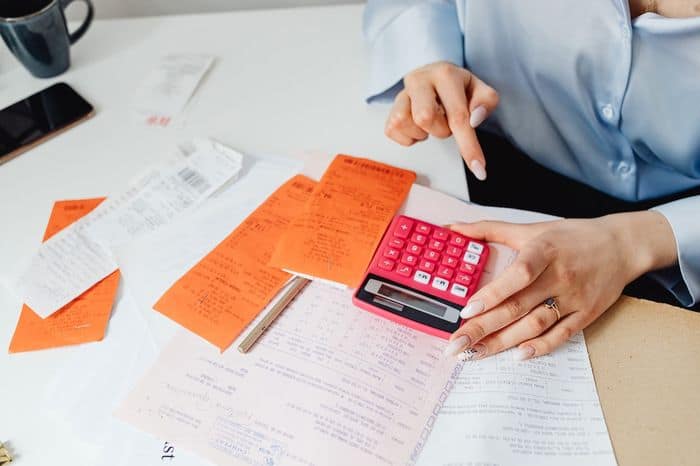 someone calculating their finances with lots of paperwork