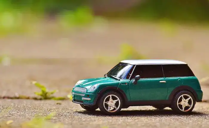 Toy Mini car in green on a paving slab.