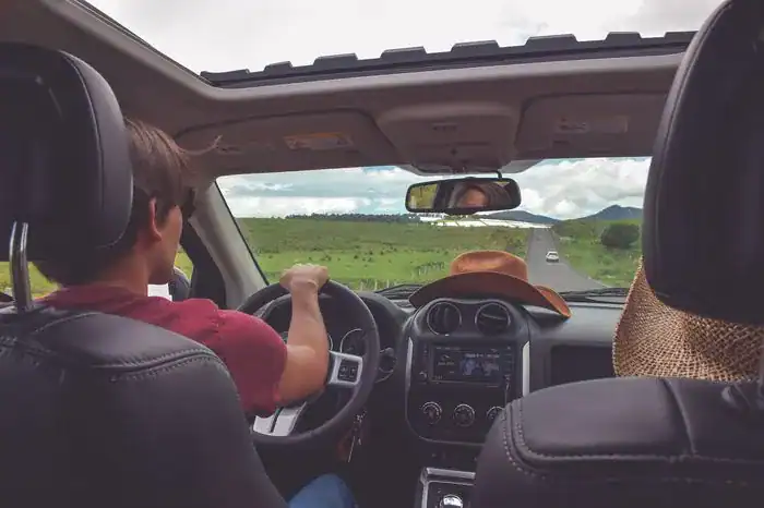 Teen driving a car down a country road for practice.
