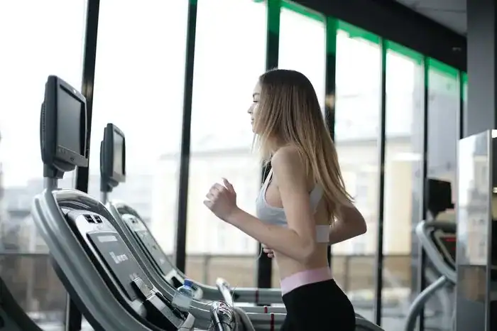 Woman running on a tredmill in a gym.