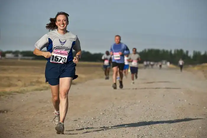 Woman the front runner in a trial running race. Wearing sturdy running shoes.