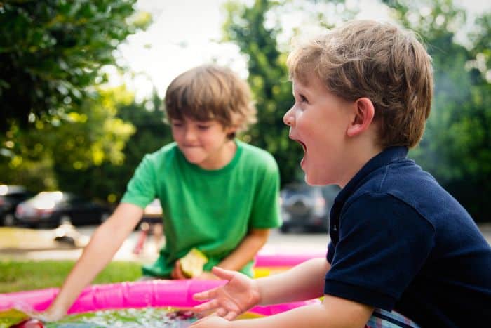 Two children having fun with outside play to get the more active.