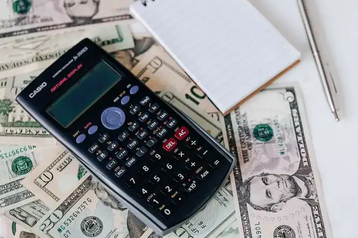 Caculator on top of money and paperwork when looking for ways to manage your money better.
