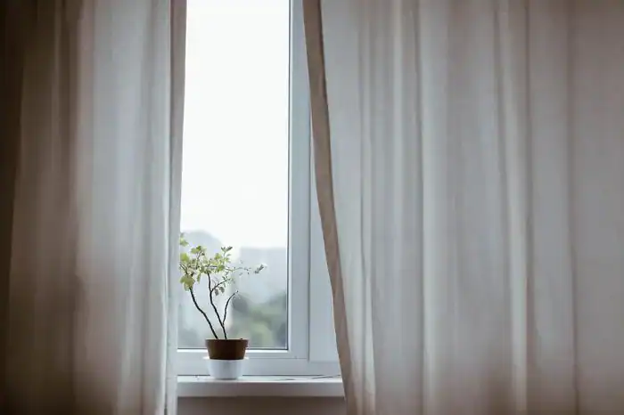 Curtains partially open in a bedroom.
