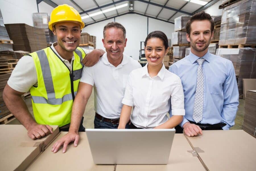 A diverse team of warehouse staff and managers standing together.
