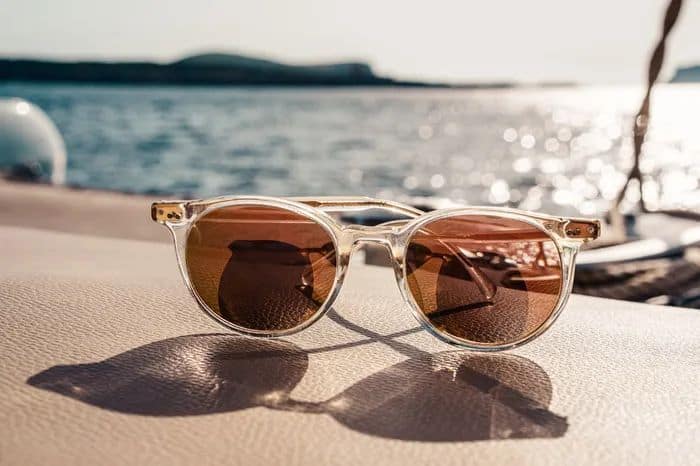 a wall near the sea with the sun shining that are ideal sunglasses for any face shape.