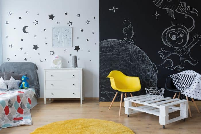 Chalkboard wall with cute designs drawn on in a child's bedroom.