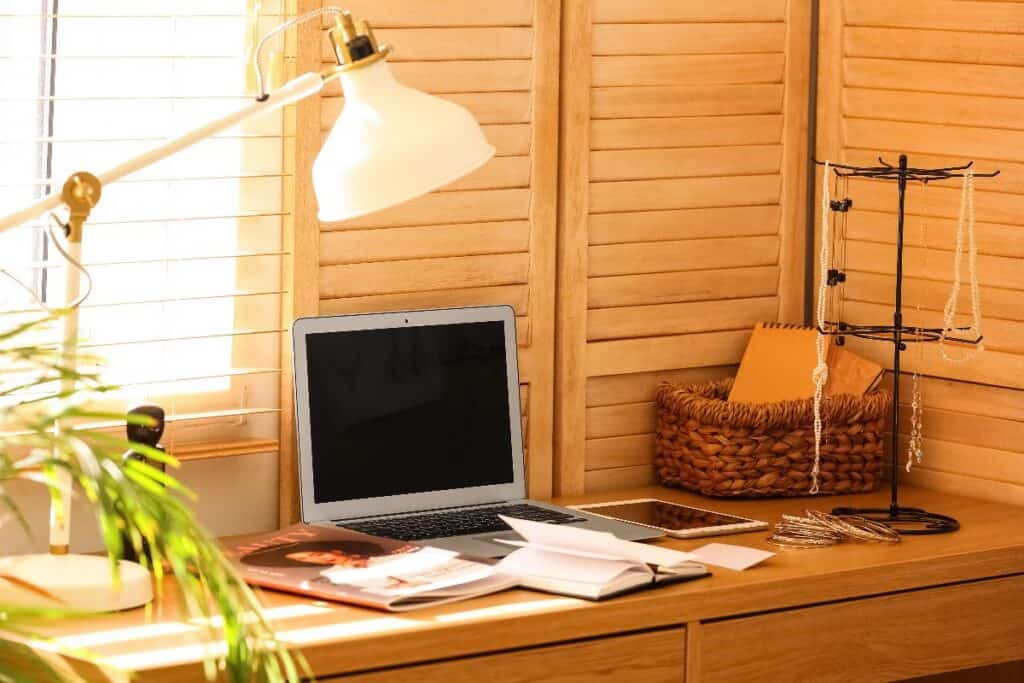 Laptop on a wooden desk inside a garden shed home office