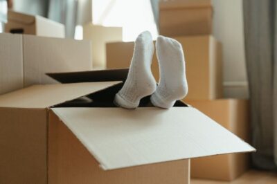 Feet sticking out of packing boxes for moving house.