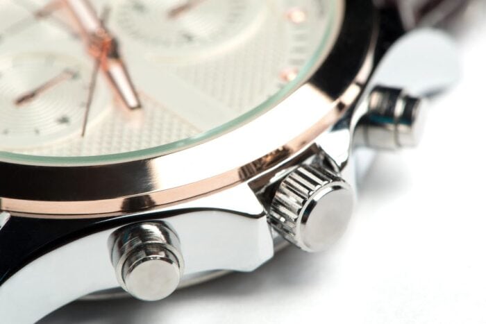 Close-up of a luxury watch showing the side buttons and a part of the watch face with intricate details.