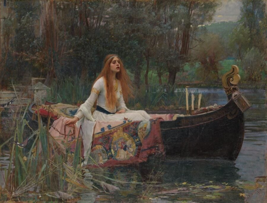 A painting by John William Waterhouse depicting the Lady of Shalott. In the scene, a woman with long red hair is sitting in a richly decorated black boat, floating on a river surrounded by lush greenery. She looks upward with a melancholic expression, dressed in a white medieval gown, as candles burn at the boat's prow.