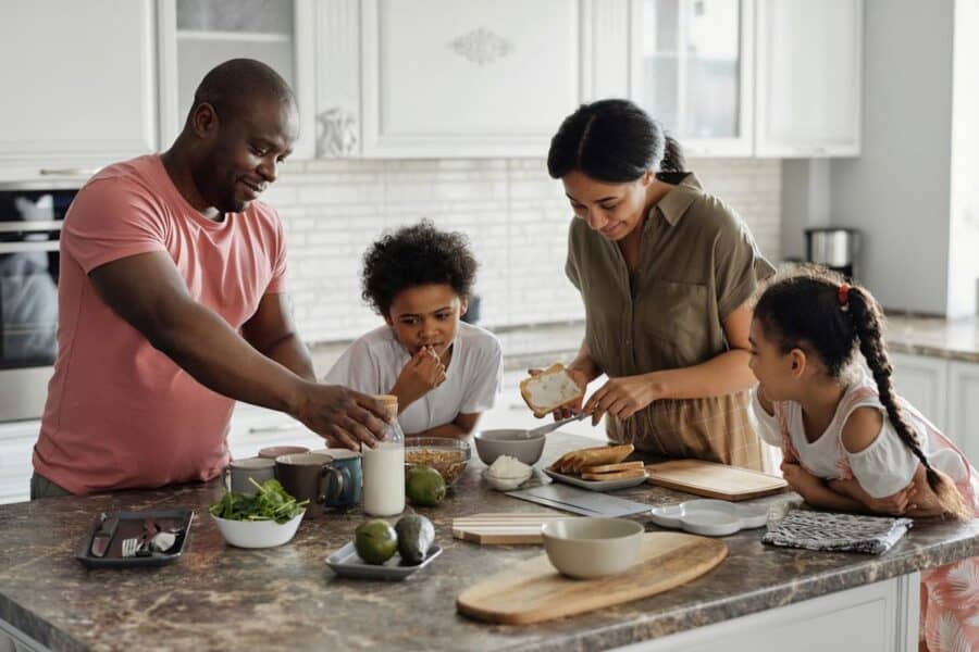 A family of four preparing a meal together in a modern kitchen, illustrating the joy of finding the perfect family home.