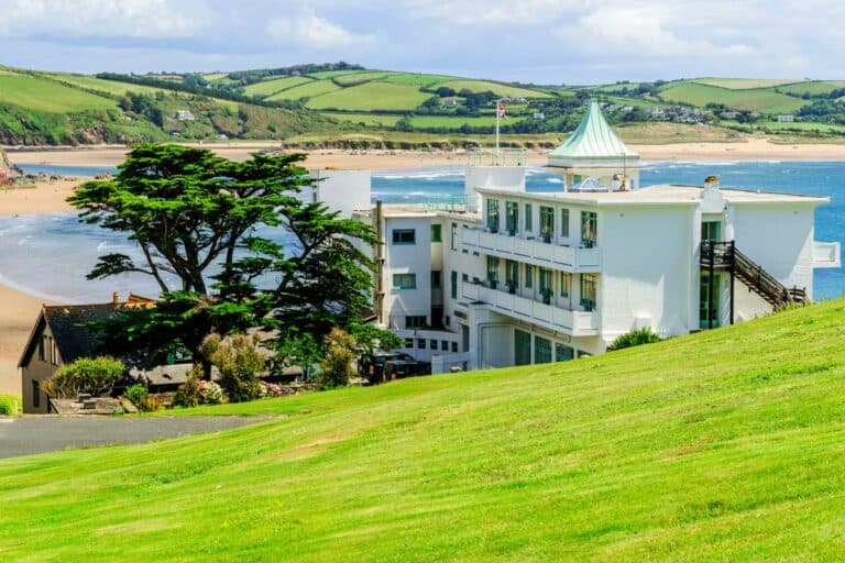 The Art Deco-style Burgh Island Hotel, one of the most unusual places to stay in Devon, overlooking the scenic coastline and sandy beaches.