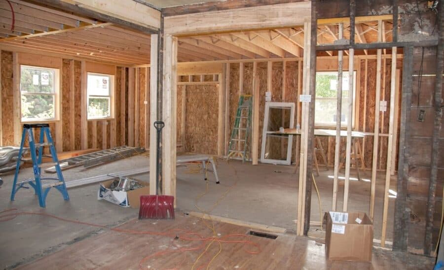 Interior of a house under renovation, with exposed wooden framing, tools, and construction materials, illustrating the importance of checking house insurance during renovations.