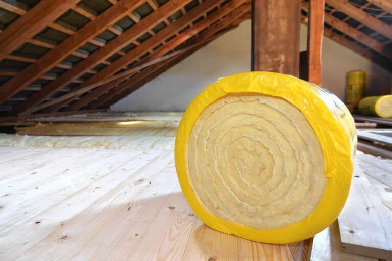 A roll of loft insulation ready to roll on a loft floor as an effective way to keep a house warm.