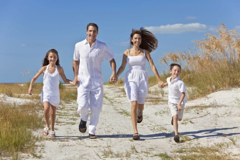 Happy family running on a sandy path outdoors, representing Parenting and Learning Essentials.