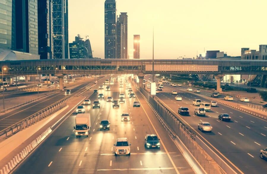 Dubai highway at sunset with busy traffic and a backdrop of modern skyscrapers, perfect for urban driving adventures in Dubai.