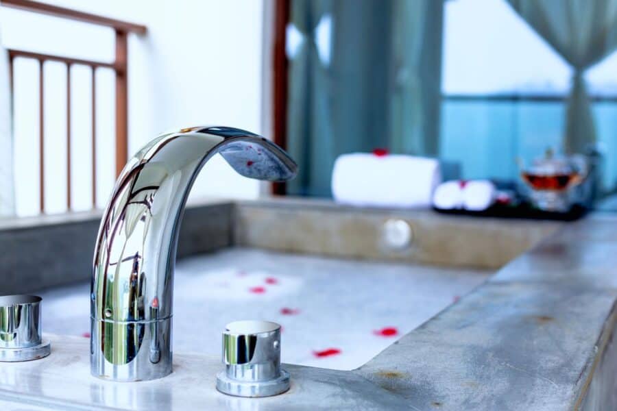 A modern bathtub filled with bubbles and rose petals, surrounded by a serene spa-like setting, perfect for a Sunday evening relaxation routine.