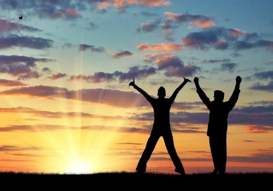 Two people celebrating success at sunrise, representing why accountability matters in achieving goals.