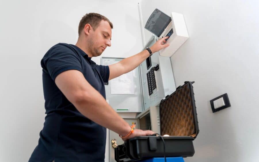 A certified electrician installing a smart electrical control panel, highlighting the importance of professional installation for smart home upgrades.