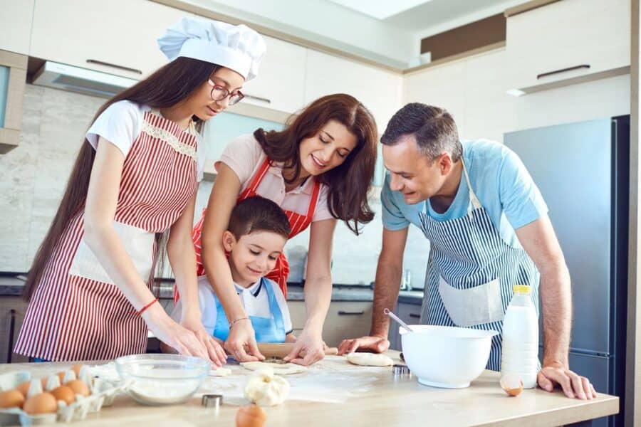 A happy family in the kitchen, baking and making homemade treats together. A perfect example of how traditions help deepen family connections.