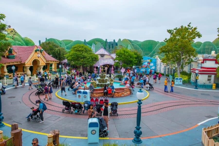 Families exploring Mickey’s Toontown at Disneyland Anaheim, with colorful buildings, a central fountain, and stroller-friendly walkways.