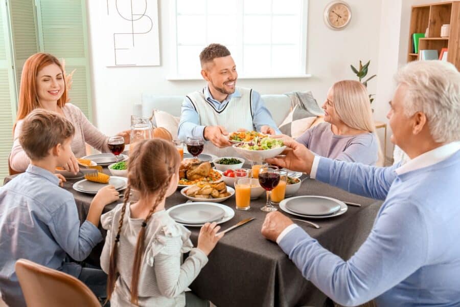 A multi-generational family enjoying a meal together, engaging in conversation and quality time without digital distractions.