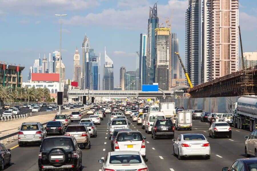 Busy traffic on Sheikh Zayed Road in Dubai with luxury cars and skyscrapers, illustrating essential road trip car rental tips for driving in the UAE.