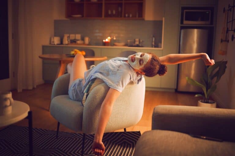 Woman enjoying a skincare ritual as part of an evening routine to help you unwind and recharge at home.