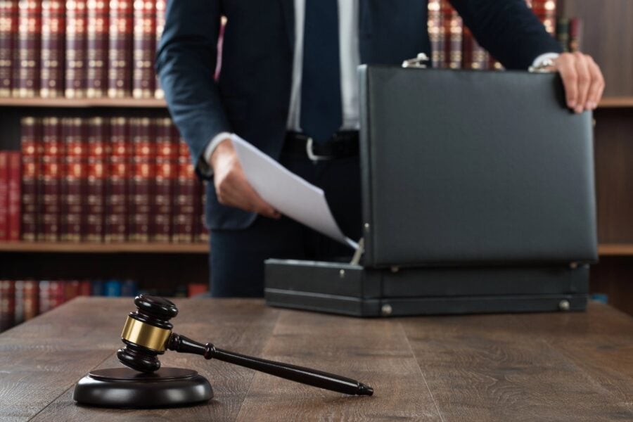 Lawyer preparing case documents in front of gavel and law books.