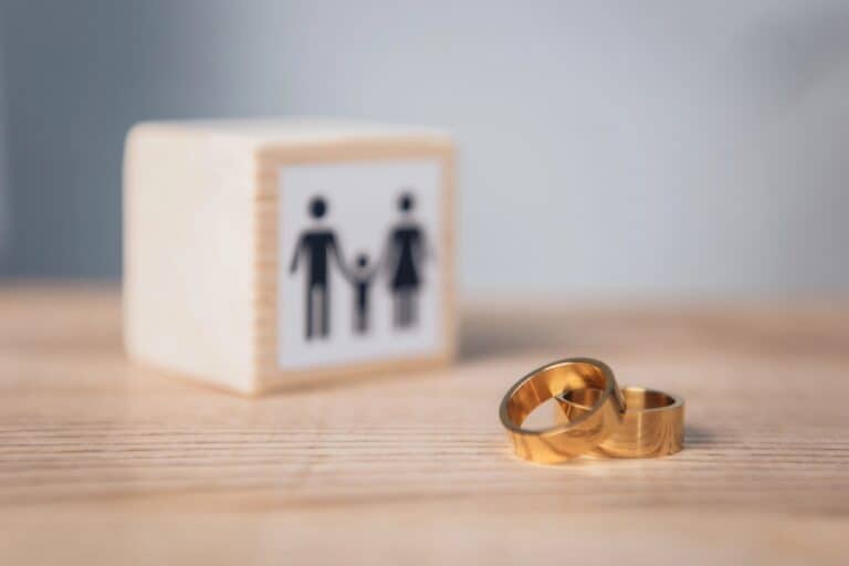 Two gold wedding rings beside a family icon block, symbolising legal options for divorce in Australia and family separation.