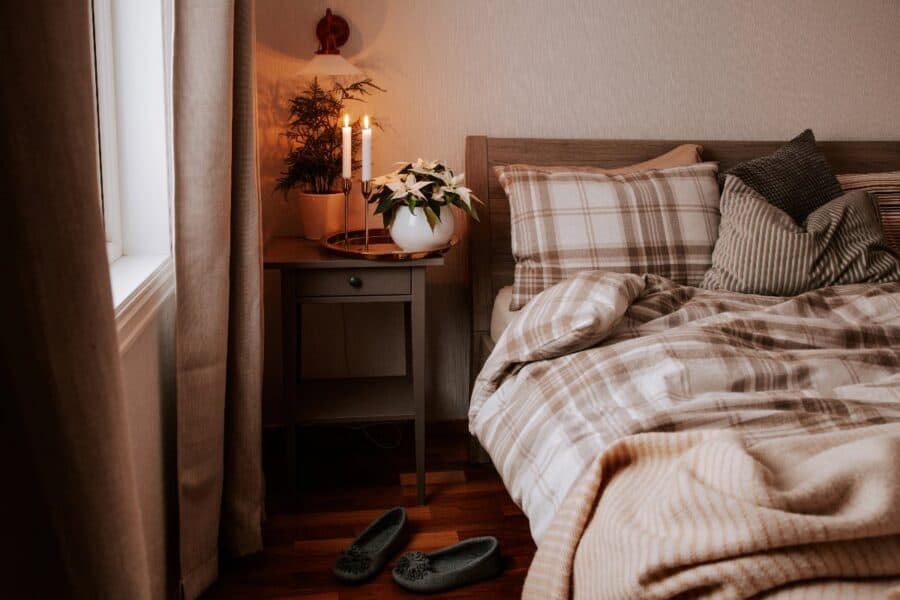 Cosy autumn bedroom reset: textured cushions, stripe throw and ambient bedside lighting.