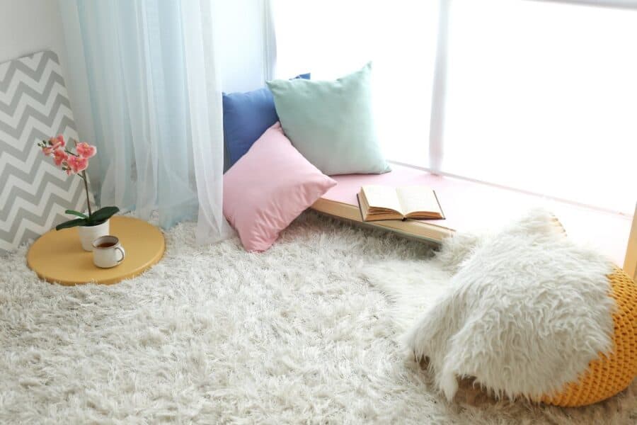 Cosy book nook project with floor cushions, fluffy rug and open book by a bright window