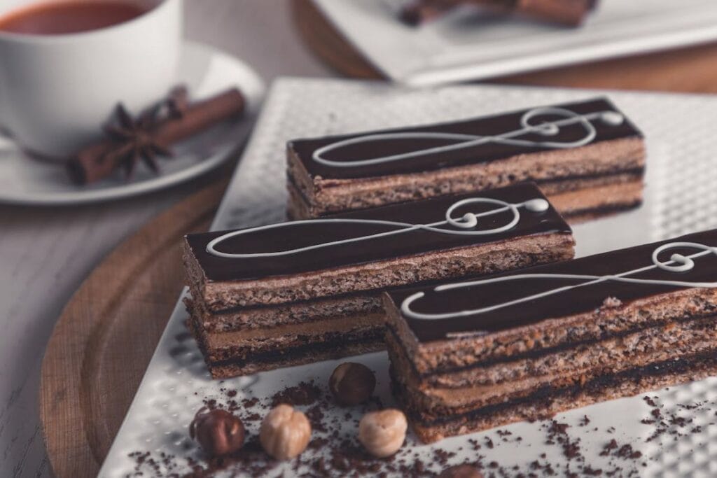 Elegant chocolate slices with hazelnuts beside a cup of tea